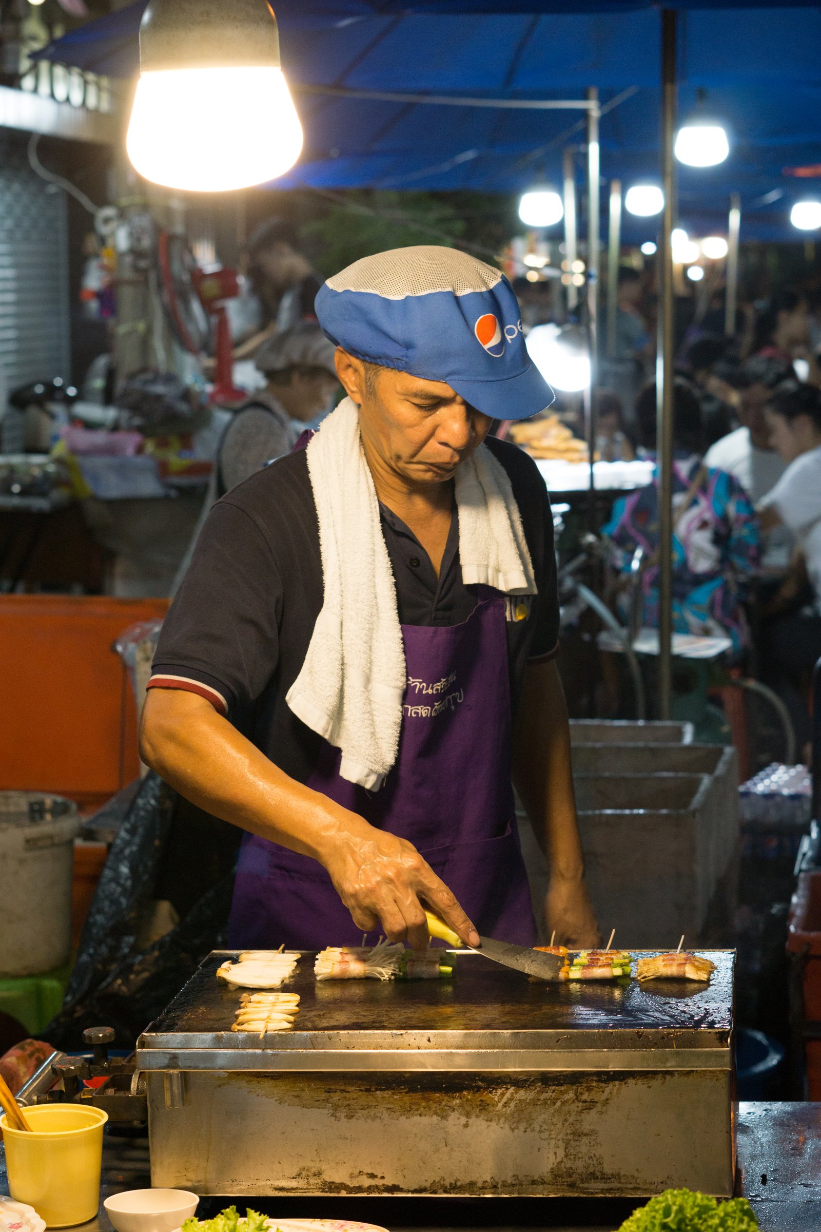 A street food vendor preparing food at a Bangkok market