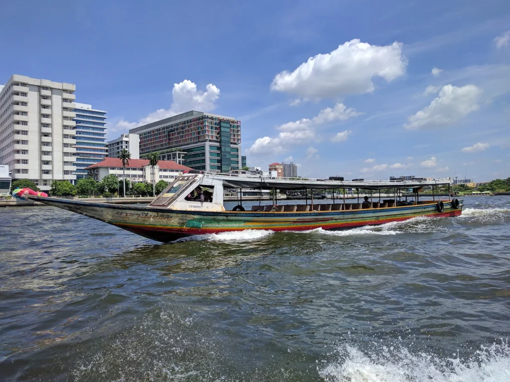 The Chao Phraya River in Bangkok at golden hour with long-tail boats