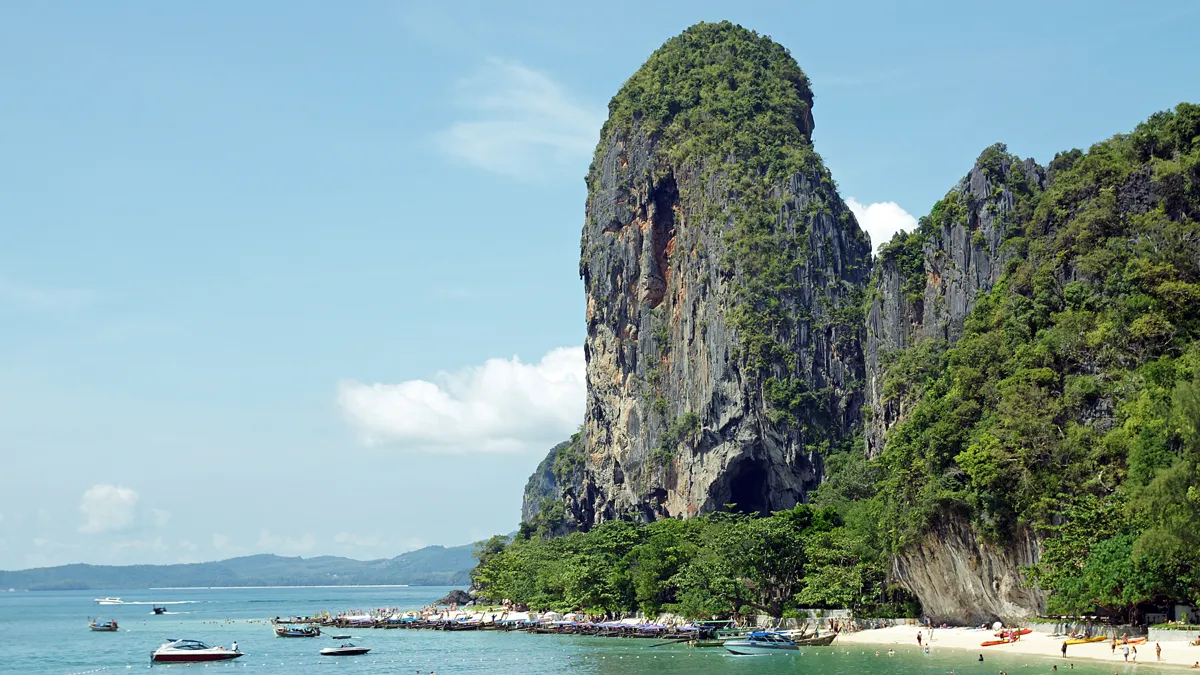 Phra Nang Cave Beach with limestone cliff and longtail boats in Krabi
