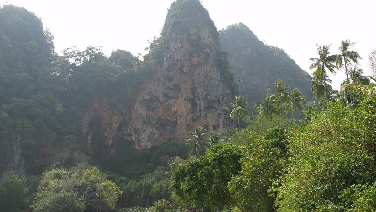 Railay East Beach with longtail boats and mangrove edge in Krabi