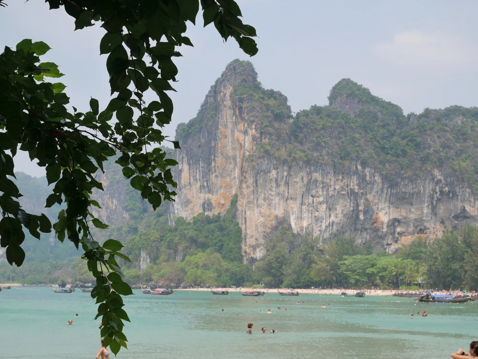 Railay West Beach with longtail boats and limestone cliffs in Krabi