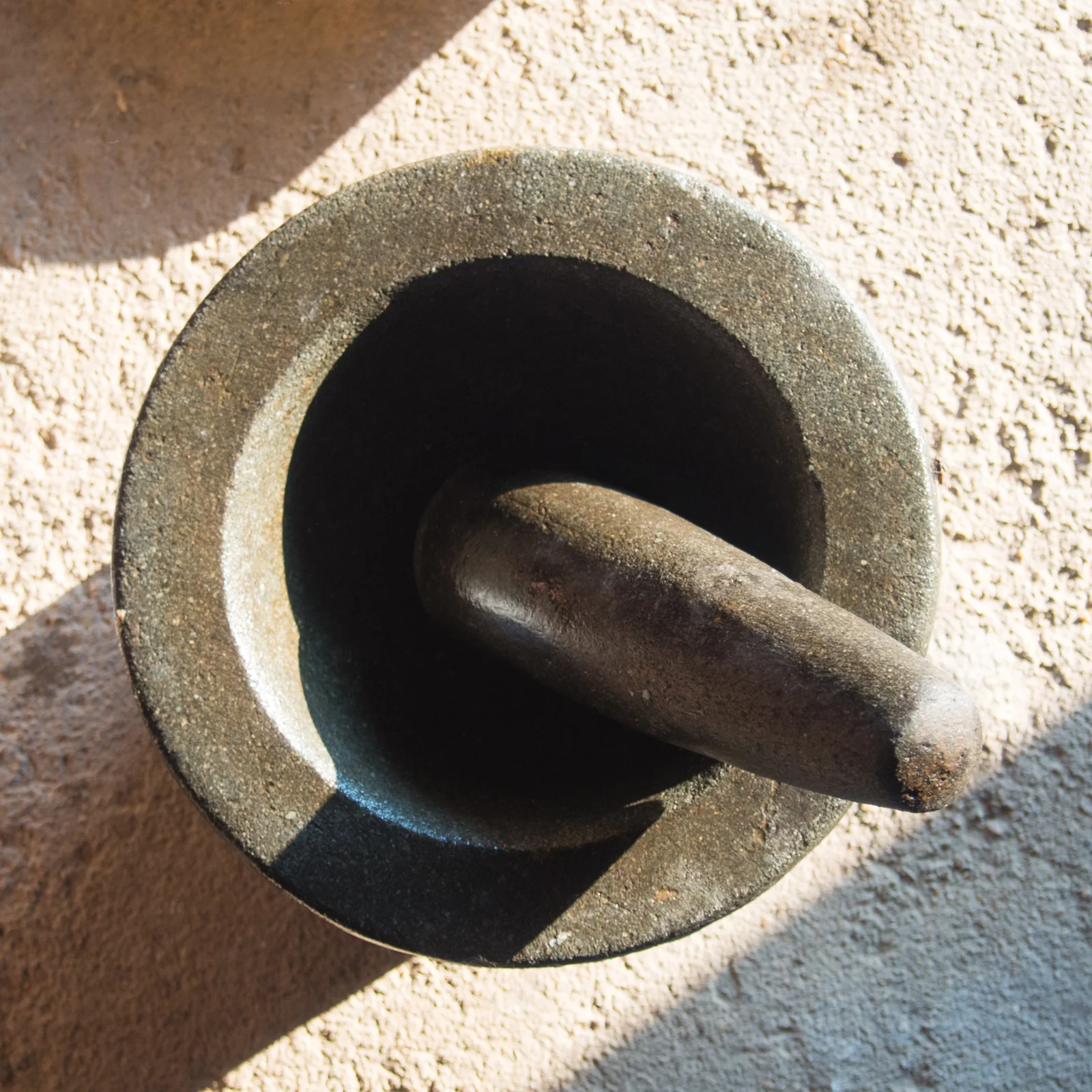 Thai granite mortar and pestle used to pound curry paste from scratch