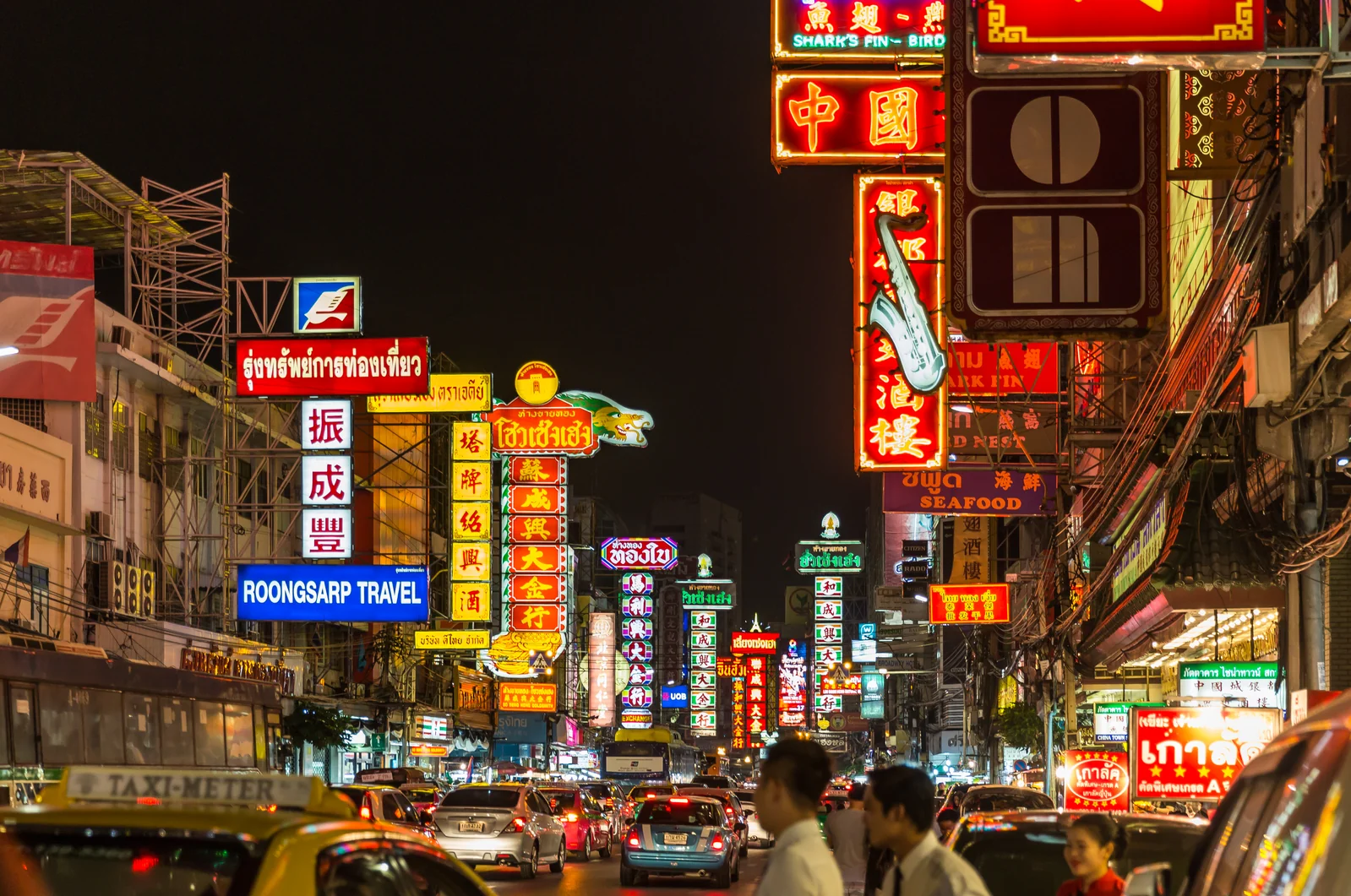 Yaowarat Road in Bangkok Chinatown at night with red and gold neon shop signage
