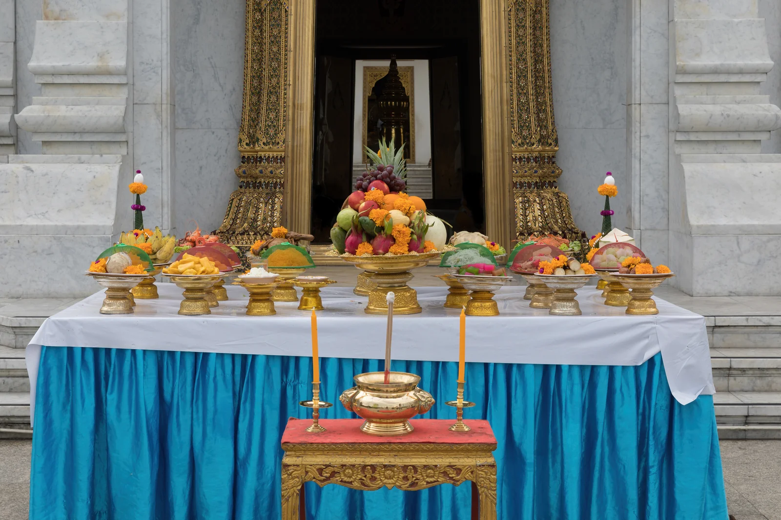 Offering table with fruit, rice and candles at the Bangkok City Pillar Shrine near the Grand Palace